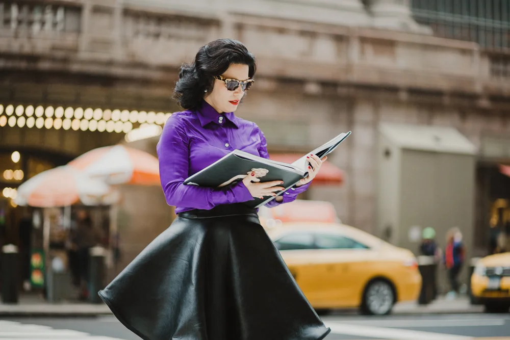 Argia Coppola reading a portfolio on East 42nd Street, near Grand Central, New York